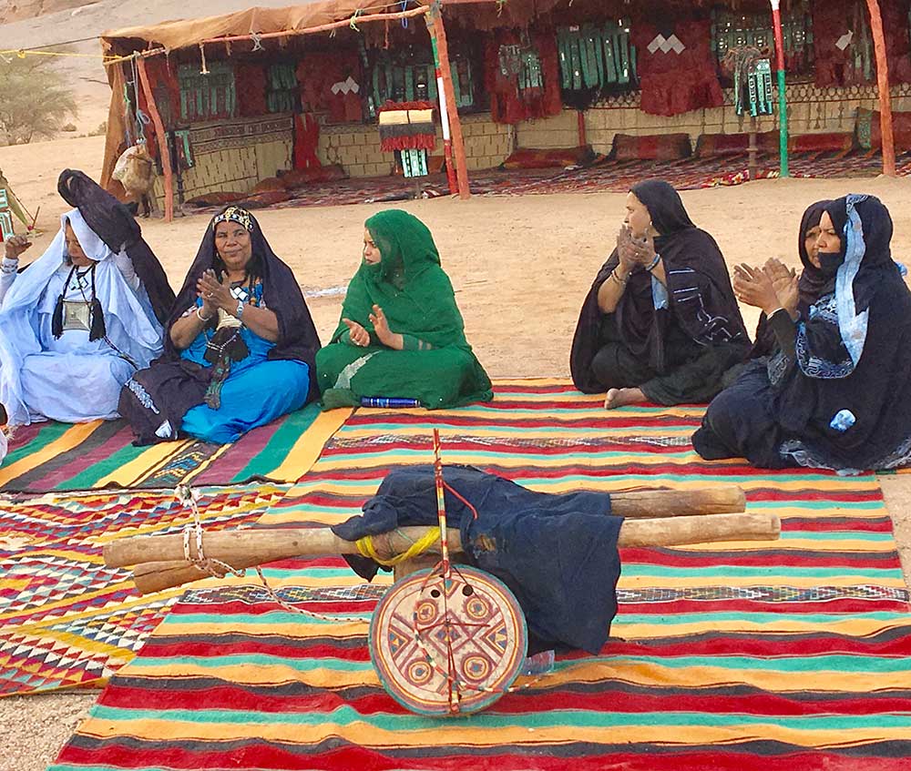 Tuareg-Frauen, im Hintergrund ein typisches Zelt mit kunstvollen Lederarbeiten.