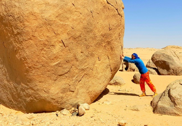 "Krafttraining" an einem Felsblock in der Sahara in der