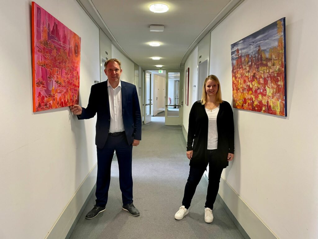 Die CDU-Landtagsabgeordneten Vanessa Odermatt und Jochen Klenner mit ihren Saharabildern von Gundhild Tillmanns im Fraktionsflur des Düsseldorfer Landtages